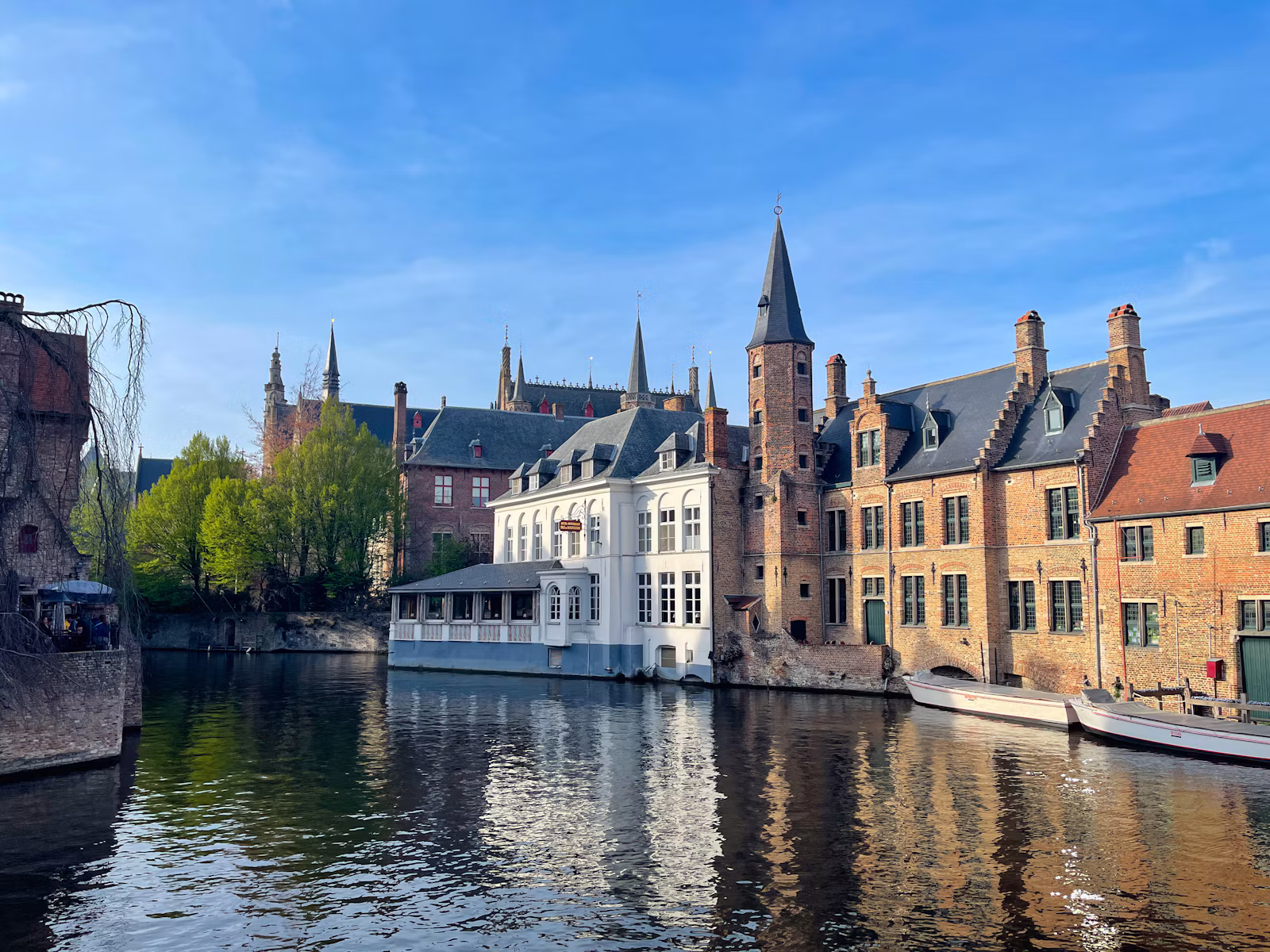 Brick houses and a belfry reflected in a canal in Bruges