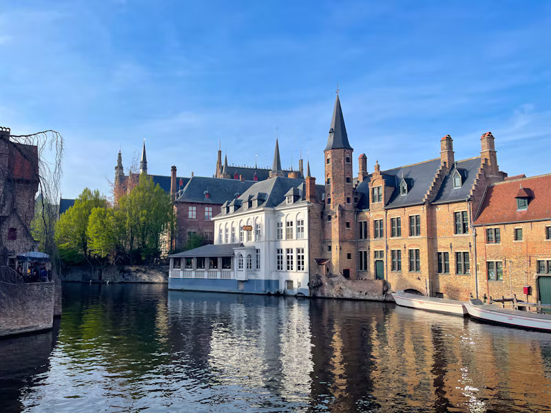 Brick houses and a belfry reflected in a canal in Bruges